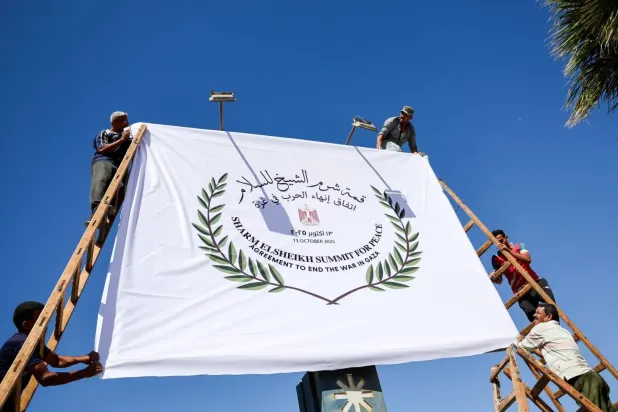 Bugün düzenlenecek Şarm eş-Şeyh Barış Zirvesi için pankart asan Mısırlı işçiler, 12 Ekim 2025 (Reuters)