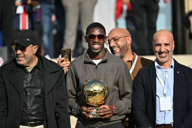 عثمان ديمبلي نجم فريق باريس سان جيرمان الفرنسي يحتفل بالكرة الذهبية في إيفرو (أ.ف.ب)