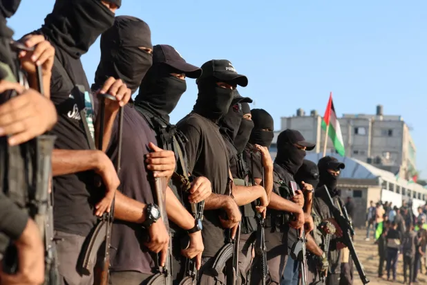 عناصر مسلحة في خان يونس قبل تسليم رهائن إسرائيليين إلى الصليب الأحمر الدولي اليوم (د.ب.أ)