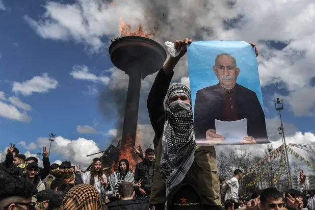أكراد في ديار بكر جنوب شرقي تركيا يرفعون صورة لعبد الله أوجلان أثناء قراءة ندائه لحل حزب «العمال الكردستاني» خلال احتفالات النوروز في 21 مارس الماضي (أ.ف.ب)