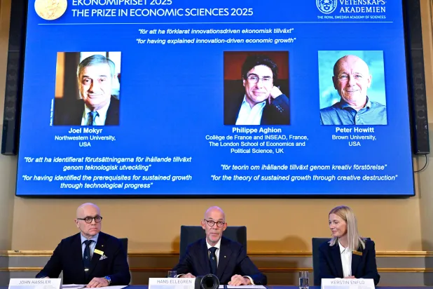 عرض صور الفائزين بالجائزة لعام 2025 (من اليسار إلى اليمين) جويل موكير وفيليب أغيون وبيتر هاويت وهم يتحدثون إلى الصحافيين أثناء الإعلان عن الفائز بجائزة نوبل في الاقتصاد (أ.ف.ب)