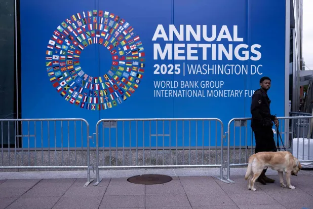 حارس أمن وكلبه يتجولان أمام مقر صندوق النقد الدولي (أ.ف.ب)