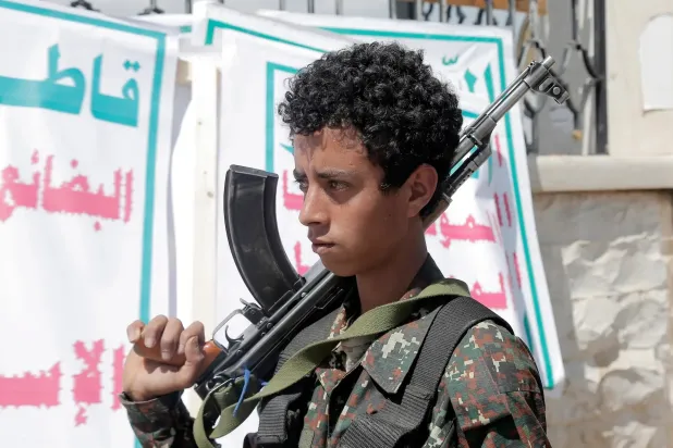 طفل جنَّدته الجماعة الحوثية يحرس إحدى فعالياتها في صنعاء (غيتي)