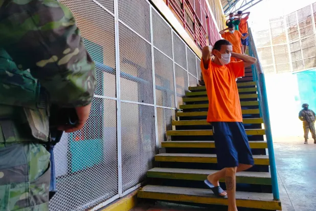 نزلاء مركز احتجاز في أثناء عملية نفذتها القوات المسلحة الإكوادورية التي صادرت هواتف محمولة ومخدرات وأسلحة حادة (أ.ف.ب)