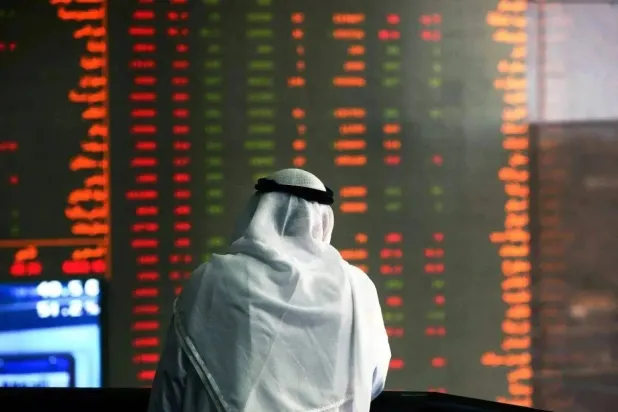 مستثمر ينظر إلى شاشة أسهم متراجعة في بورصة الكويت (أ.ف.ب)
