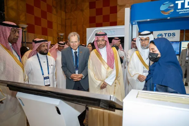 الخريّف يستمع لشرح من أحد العارضين في منتدى في جدة (الشرق الأوسط)