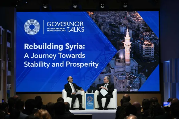 وزير المالية السوري ومدير إدارة الشرق الأوسط في صندوق النقد الدولي خلال جلسة نقاش خاصة بسوريا (أ.ف.ب)