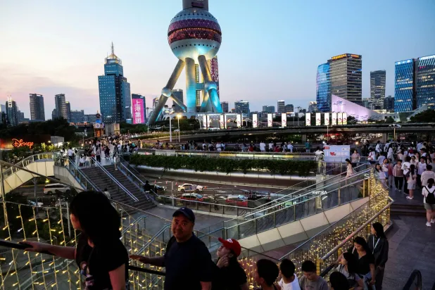 مشاة في الضاحية المالية بمدينة شنغهاي الصينية (رويترز)