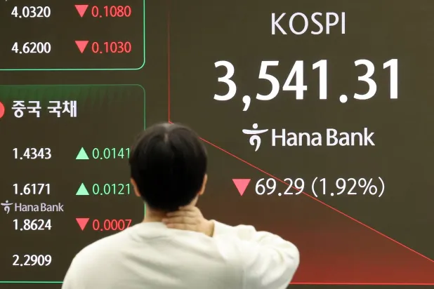 متداول أمام شاشة تعرض مؤشر «كوسبي» في غرفة التداول ببنك هانا في سيول (إ.ب.أ)