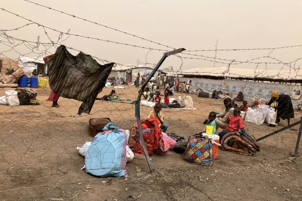لاجئون من السودان ينتظرون خلف معبر الحدود إلى جنوب السودان (د.ب.أ)