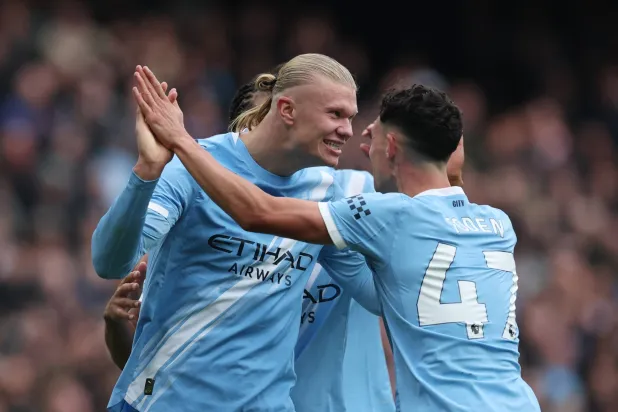 فيل فودين يعانق زميله النرويجي إيرلينغ هالاند في مواجهة إيفرتون (رويترز)