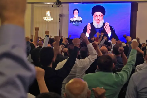 Beyrut'un güney banliyösündeki bir camide dev ekranda Hasan Nasrallah'ın konuşmasını izleyen Hizbullah destekçileri, Kasım 2019 (AFP)