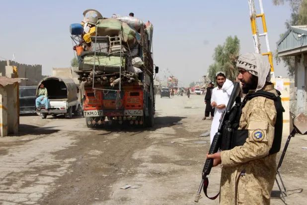 Afgan güvenlik güçleri, Kandahar'daki sınır kapısının açılmasının ardından vatandaşlarının Spin Boldak eyaletine dönüşünü izliyor- 19 Ekim (EPA)