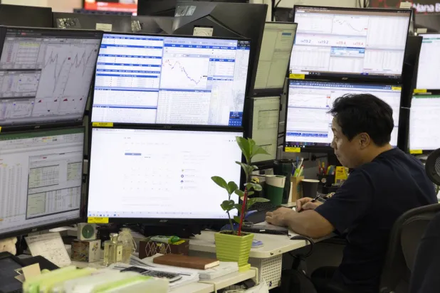 متداول يراقب شاشات تعرض مؤشرات الأسهم في بنك «هانا» بالعاصمة سيول (إ.ب.أ)