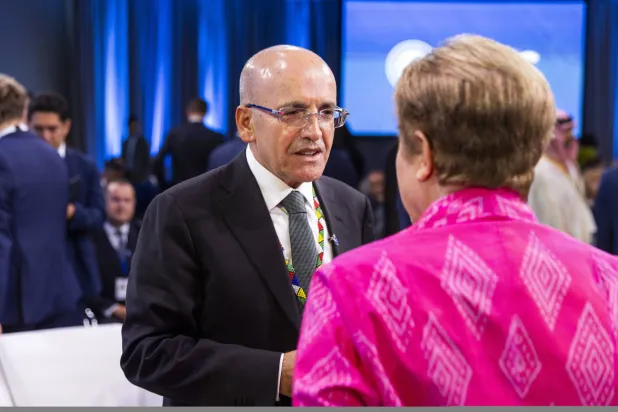 وزير المالية التركي محمد شيمشك يتحدث مع المديرة العامة لصندوق النقد الدولي كريستالينا غورغييفا خلال اجتماع اللجنة الدولية للشؤون المالية والنقدية في واشنطن (إ.ب.أ)