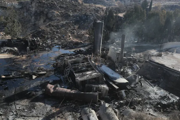 أشخاص يتفقدون الأضرار التي لحقت بمصنع للأسمنت بسبب الغارات الجوية الإسرائيلية على قرية أنصار بجنوب لبنان الجمعة (أرشيفية - أ.ب)