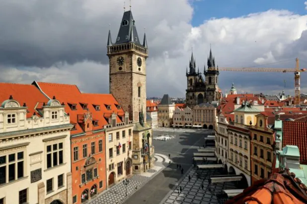 A clock showing the time at noon is pictured on a building, next to almost empty streets at Old Town Square during the coronavirus disease (COVID-19) outbreak, in Prague, Czech Republic, March 31, 2020. REUTERS/David W Cerny 