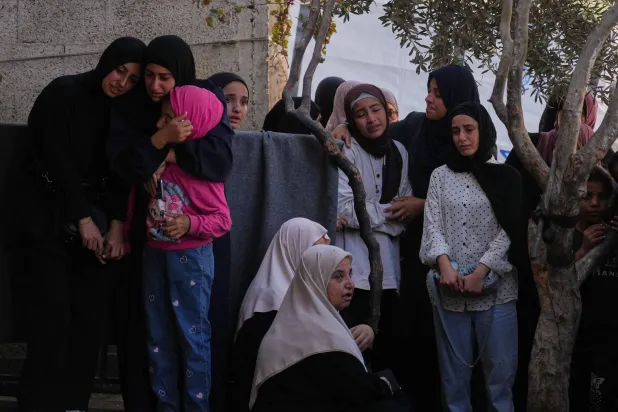 فلسطينيون خلال تشييع جثامين قتلى قصف إسرائيلي يصطفون في مستشفى وسط قطاع غزة يوم الاثنين (أ.ب)