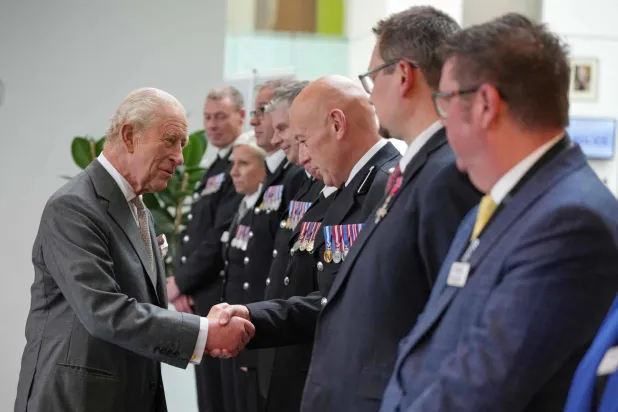 التقى الملك تشارلز الثالث ملك بريطانيا العظمى (يساراً) أفراد خدمات الطوارئ في مقر شرطة مانشستر الكبرى شمال غربي إنجلترا أمس (أ.ف.ب)