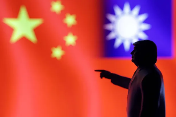 ظل الرئيس الأميركي دونالد ترمب وفي الخلفية علما الصين وتايوان (رويترز)