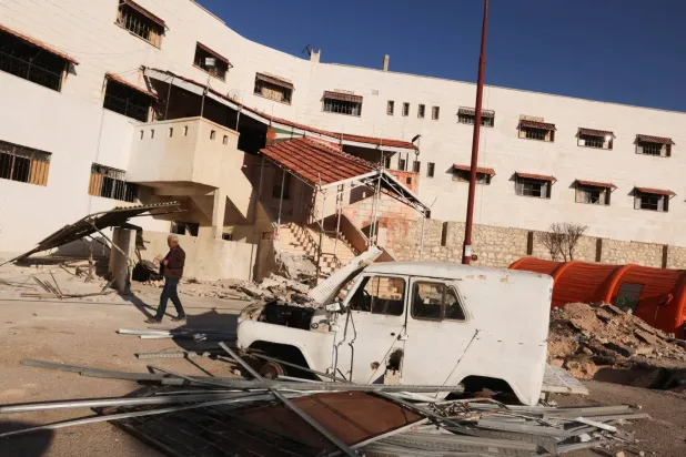 Sednaya Hapishanesi önündeki enkazın arasında park halindeki bir araç (Arşiv – Reuters)