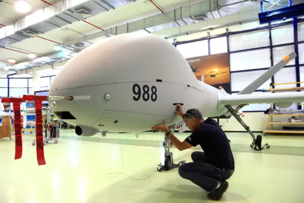 عامل إسرائيلي يتفقد مسيرة من طراز «هيرمز 900» عام 2018 (أرشيفية - رويترز) 