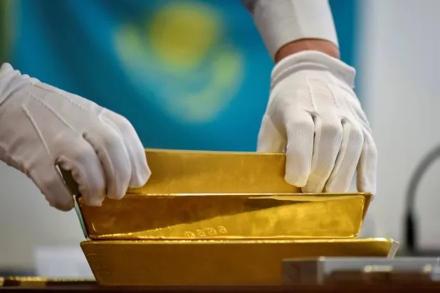 موظف يضع سبائك ذهب بخزانة البنك الوطني الكازاخستاني في ألماتي (رويترز)