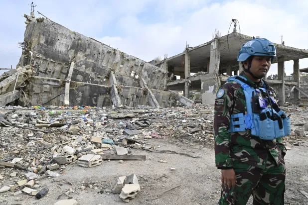 عنصر في «يونيفيل» يقف أمام أنقاض منزل مدمر ببلدة العديسة جنوب لبنان (إ.ب.أ)