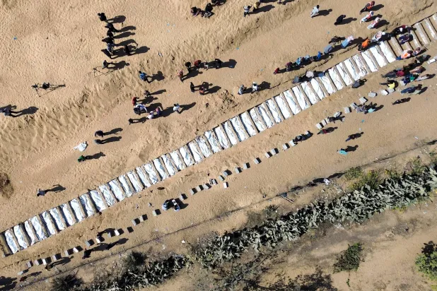 رفات وجثث فلسطينيين مجهولي الهوية أعادتهم إسرائيل أثناء دفنهم في مقبرة جماعية بدير البلح وسط قطاع غزة أمس (إ.ب.أ)
