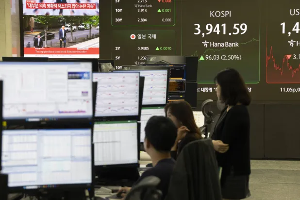 متعاملون كوريون جنوبيون يعملون أمام شاشات في بنك هانا بسيول (إ.ب.أ)