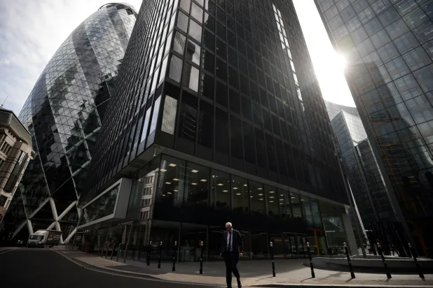 شخص يمشي في حي المال في سيتي لندن (رويترز)