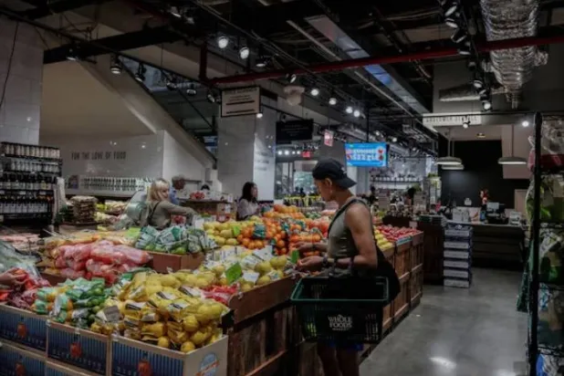 يتسوق أشخاص لشراء البقالة في متجر بمدينة نيويورك (رويترز)