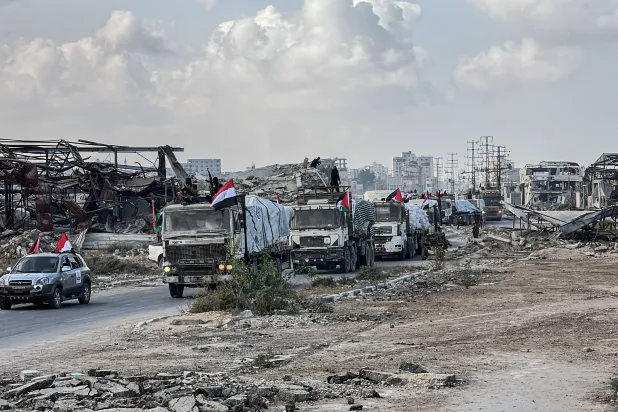 قافلة من شاحنات المساعدات الانسانية قادمة من مصر تشق طريقها وسط الدمار في النصيرات بقطاع غزة أمس (د.ب.أ)