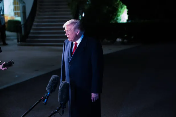 ترمب يُشير بيده أثناء حديثه إلى وسائل الإعلام قبل صعوده على متن الطائرة في طريقه إلى ماليزيا (د.ب.أ)