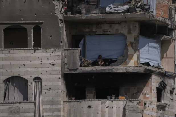 أطفال فلسطينيون في مبنى متضرر بشدة في مخيم الشاطئ بمدينة غزة (أ.ب)