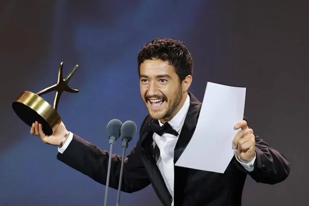 أحمد مالك مبتهجاً بأنه أول مصري يفوز بجائزة أفضل ممثل بمهرجان الجونة (إدارة المهرجان)