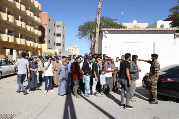 Libya'daki yüzlerce Suriyeli mülteci, Şam'ın sunduğu ücretsiz dönüş biletlerinden yararlanmak için Trablus'taki bir seyahat acentesine akın etti. (AFP)