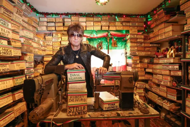Shoemaker Chris Francis poses with boxes containing the carved molds of celebrities' feet made by Pasquale Di Fabrizio, who made shoes for Hollywood stars for decades. VALERIE MACON / AFP
