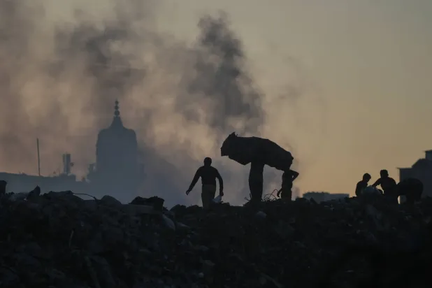 Gazze şehrinde enkaz ve çöp yığınlarının arasında işe yarar eşya arayan Filistinliler (AP)