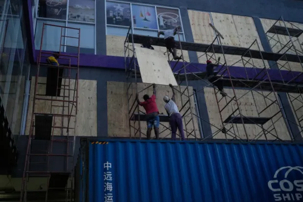 Workers board up shop windows ahead of Hurricane Melissa’s forecast arrival in Kingston, Jamaica, Sunday, Oct. 26, 2025. (AP Photo/Matias Delacroix)
