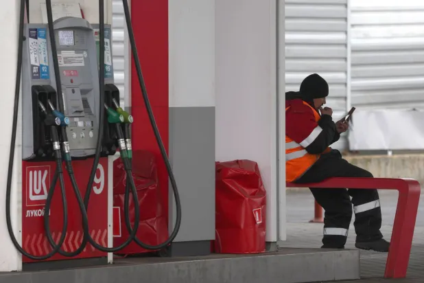 عامل ينتظر الزبائن في محطة وقود تابعة لشركة «لوك أويل» ينتظر السيارات في موسكو (إ.ب.أ)