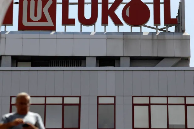 رجل يسير أمام مقر شركة «لوك أويل» في صوفيا (رويترز)