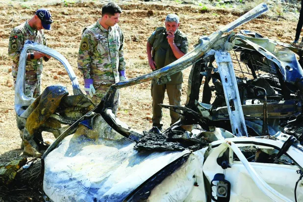 Lebanese army soldiers stand next to the wreckage of a vehicle targeted by an Israeli drone in the village of Harouf in the Nabatieh Governorate, southern Lebanon, 25 October 2025. EPA/STRINGER