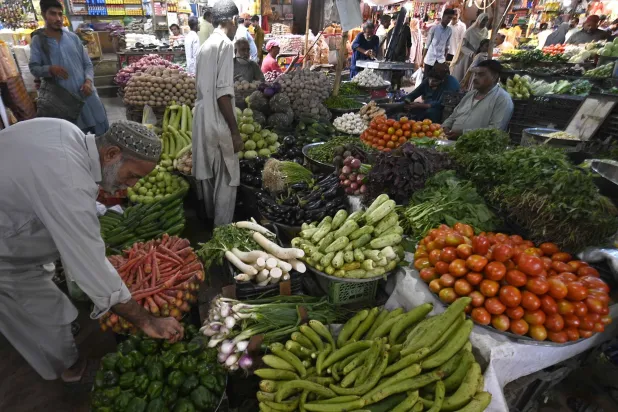بائع يعرض الخضراوات بإحدى الأسواق في باكستان (إ.ب.أ) 