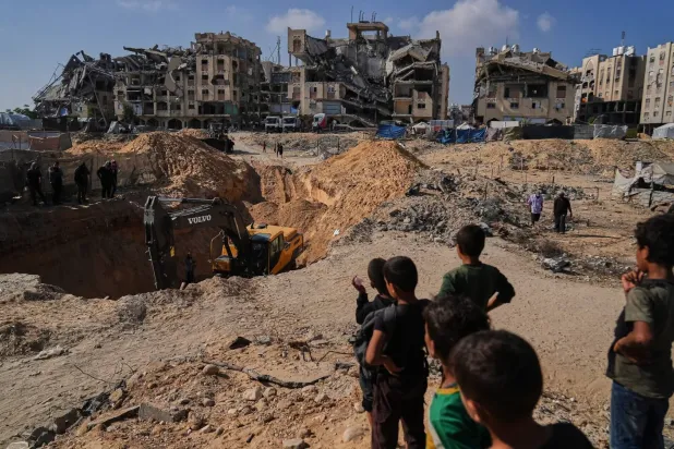 Filistinliler, dün Gazze Şeridi'nin güneyindeki Han Yunus'a bağlı Hamad şehrinde rehinelerin cesetlerini ararken Mısır'ın makineleri ve çalışanları izliyor (AP)