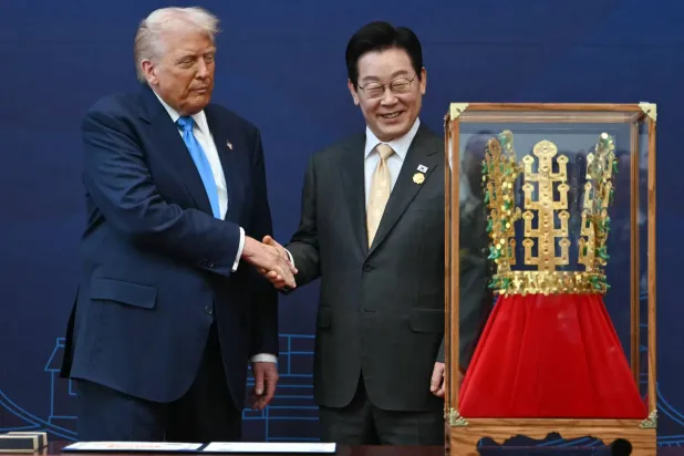 US President Donald Trump (L) shakes hands with South Korean President Lee Jae Myung during a high honor presentation ceremony, where Trump was presented with a replica of a crown worn by the kings of Silla, at the Gyeongju National Museum in Gyeongju on October 29, 2025. (Photo by ANDREW CABALLERO-REYNOLDS / AFP)