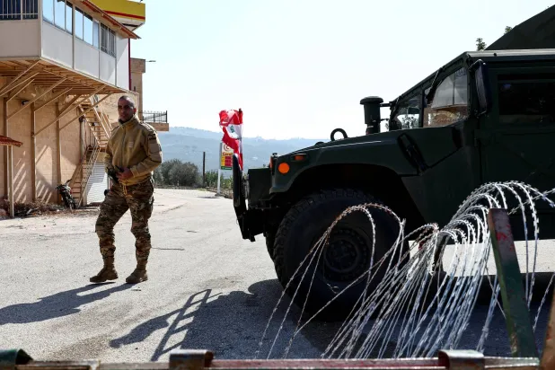 عنصر بالجيش اللبناني إلى جانب آلية عسكرية في بلدة ديرميماس جنوب لبنان فبراير 2025 (أرشيفية - رويترز)