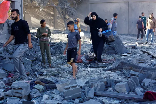 Palestinians inspect the site of an overnight Israeli strike on a house, in Nuseirat, central Gaza Strip, October 29, 2025. REUTERS/Mahmoud Issa 