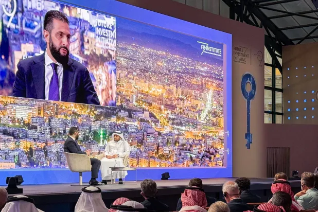 Syria's interim President Ahmed Al-Sharaa (L) speaks during the Future Investment Initiative (FII9) conference in Riyadh on October 29, 2025. (AFP) 