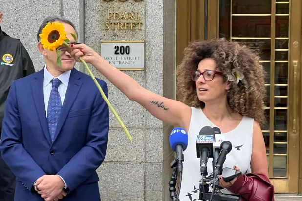 İran asıllı Amerikalı gazeteci Masih Alinejad, kararın ardından adliye binasının dışında çiçek uzatıyor (AFP)